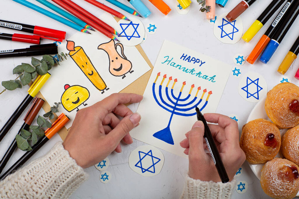 Jewish holiday Hanukkah greeting cards on gray concrete background. Hanukkah food doughnuts. Top view, flat lay, mockup - Foto, Imagem