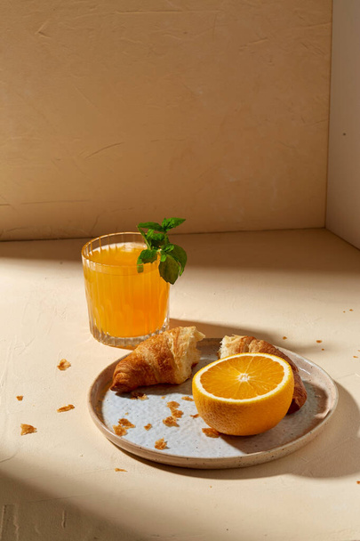 glass of orange juice and croissant on plate - Φωτογραφία, εικόνα