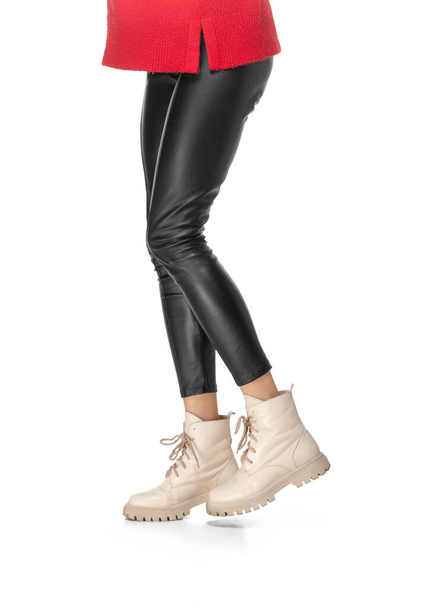 Shapely female legs in leather leggings and boots isolated on white background - Photo, Image