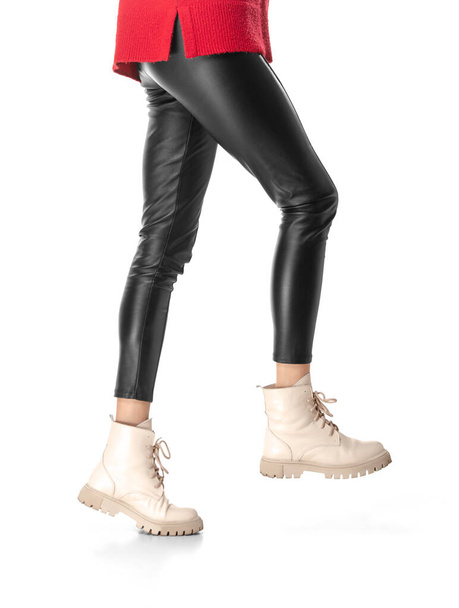Patas delgadas de mujer en leggins negros y botas aisladas sobre fondo blanco - Foto, Imagen