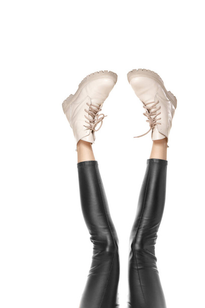 Красивые длинные тонкие женские ноги в стильных сапогах на белом фоне - Фото, изображение