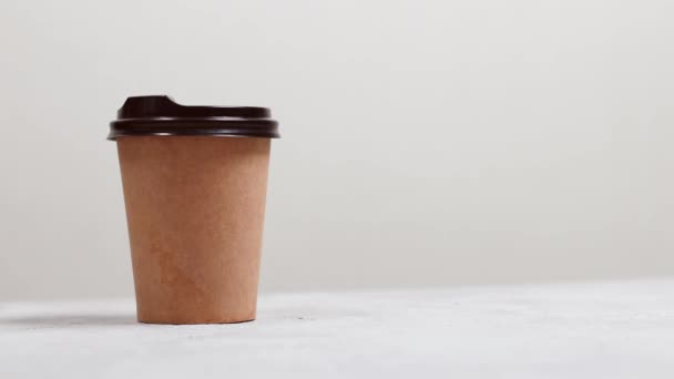 Бумажная чашка горячего кофе с пластиковой крышкой заряжать энергию утром в кафе - Кадры, видео