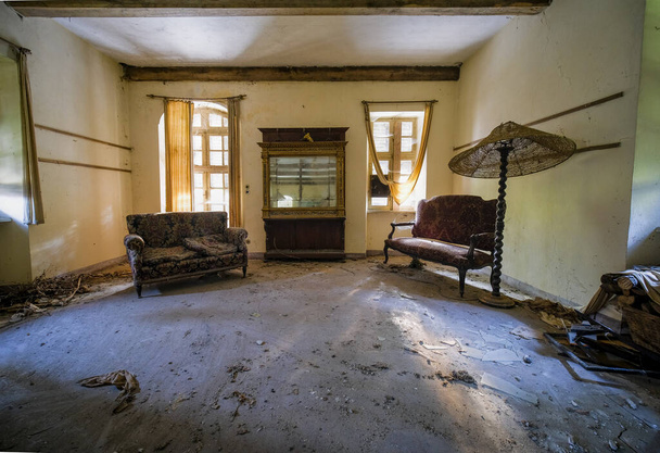 amplio salón con sofás y pantalla de lámpara en casa abandonada. foto de alta calidad - Foto, imagen