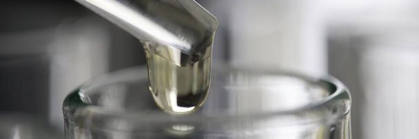 Transparent liquid is dropped from pipette into test tube closeup - Fotó, kép