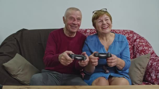 Senior couple play playstation with joysticks. The spouse loses and gets nervous. - Footage, Video