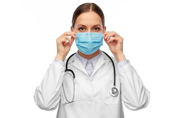 happy female doctor wearing medical mask - Foto, imagen