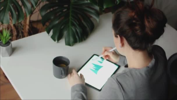 Vrouw tekent winter illustratie op touchscreen met behulp van stylus thuis - Video