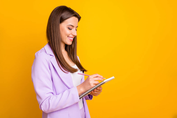 Profile photo of business lady holding diary writing corporate notes for boss responsible assistant corporate meeting conference wear purple office suit isolated yellow color background - Φωτογραφία, εικόνα