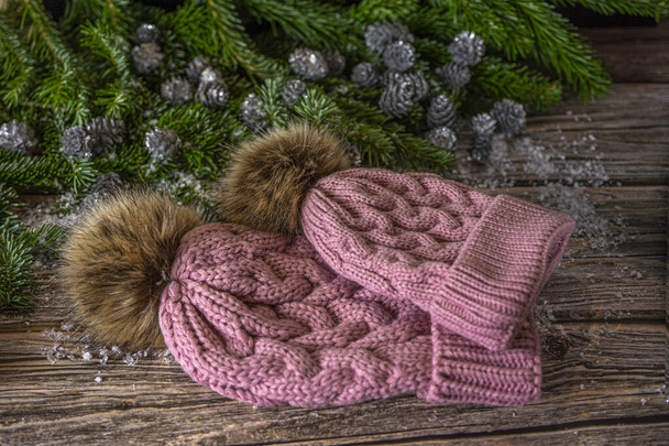 Ciepłe różowe czapki z pomponem dla mamy i córki. Ozdoba świąteczna na drewnianym tle, płaska.  - Zdjęcie, obraz