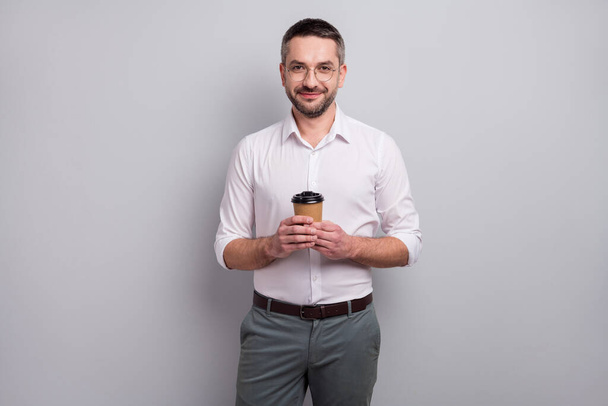 Portrait of his he nice attractive cheery calm content classy mature man holding in hands drinking hot sweet cacao having good day isolated over light gray pastel color background - Фото, зображення