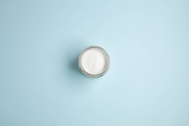Collagen powder or protein in a glass bowl on blue background with copy space. Healthy lifestyle concept. Top view, flat lay. - Foto, afbeelding