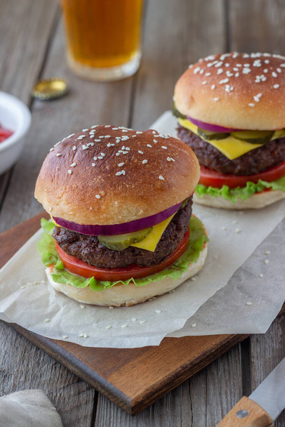 Burgers with meat, tomato, cucumber, cheese and onion. American cuisine. Fast food - Photo, image