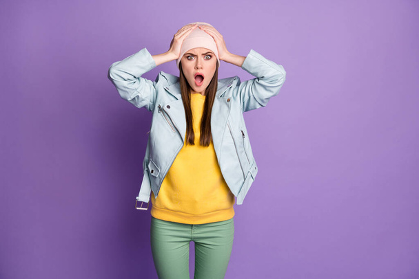 Photo of crazy shocked attractive lady teenager hold arms on head open mouth listen awful quarantine news wear casual hat blue modern jacket pants isolated purple color background - Zdjęcie, obraz