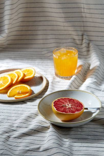 Grapefruit, in Scheiben geschnittene Orange und ein Glas Saft - Foto, Bild