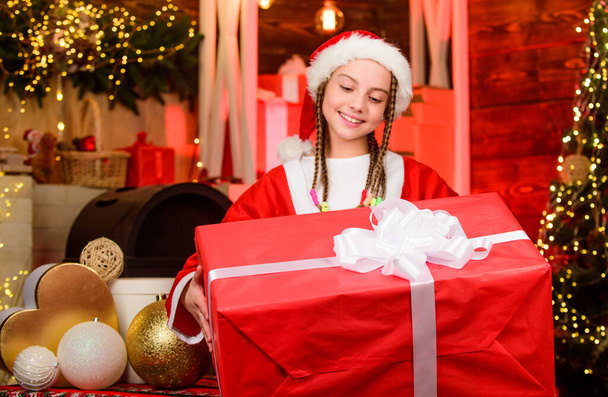 Rewarding concept. Child having fun christmas eve. Happiness and joy. Girl Santa claus costume received gift. Santa crew. Santa party. Happy new year. Big surprise. Winter present. Generous holiday - Photo, image