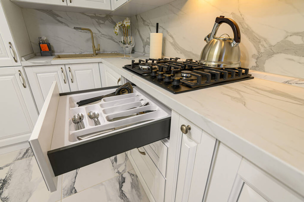 Gavetas abertas com utensílios de cozinha na cozinha branca moderna - Foto, Imagem