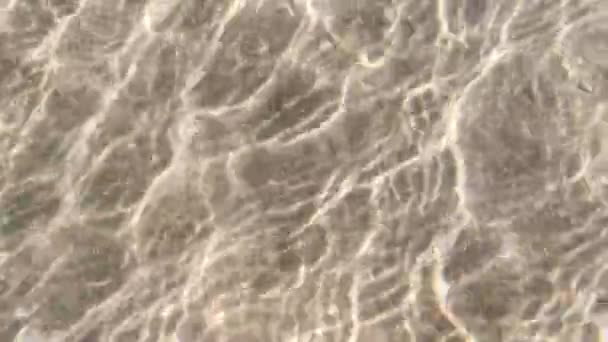 Texturas abstratas de água do mar e areia. Luz bege iridescente linhas naturais. Fundo do mar criativo. ondulações e raios de sol na superfície do mar. vista superior, uma brisa leve sopra afastado as ondas. - Filmagem, Vídeo