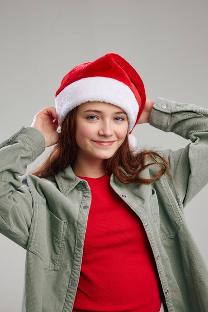 όμορφο κορίτσι σε ένα σακάκι με ένα καπέλο στο κεφάλι της χαμόγελο Χριστούγεννα Πρωτοχρονιά - Φωτογραφία, εικόνα