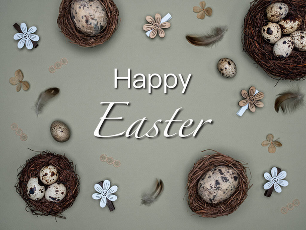 Easter, zero waste concept. Quail eggs in nests, feathers and easter decoration made from natural material. Overhead view with text: Happy Easter. - 写真・画像