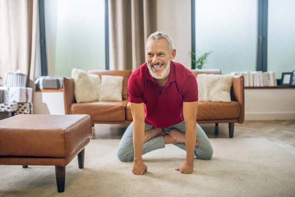 Šedovlasý pohledný muž dělá jógu a cítí se dobře - Fotografie, Obrázek