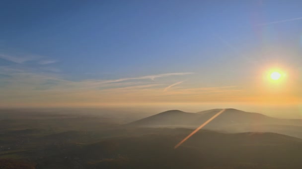Oranje zonsondergang boven berglandschap met majestueuze zonnige balken. - Video