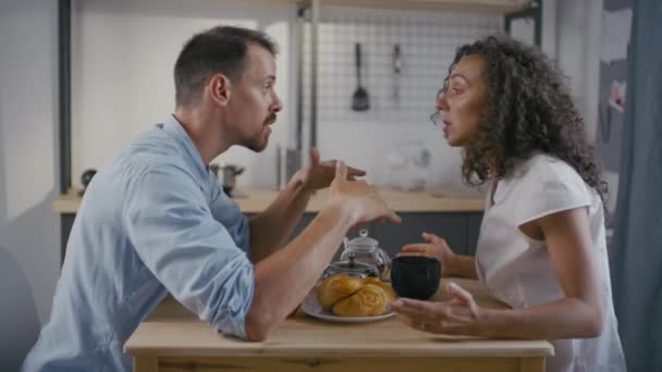 Imágenes de cámara lenta media de pareja caucásica irritada peleando señalándose los dedos y gritándose unos a otros durante el desayuno en casa - Metraje, vídeo