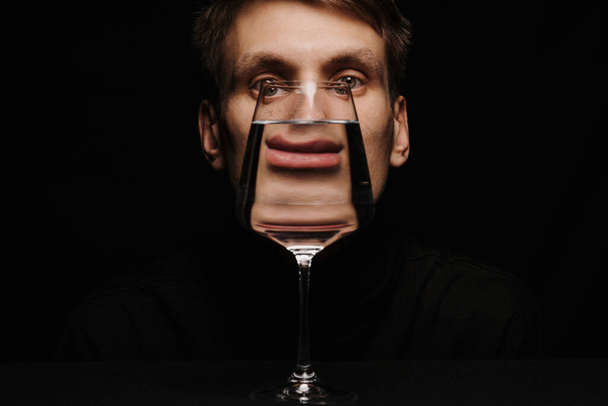 unusual portrait of a man looking through a glass of water - Photo, Image