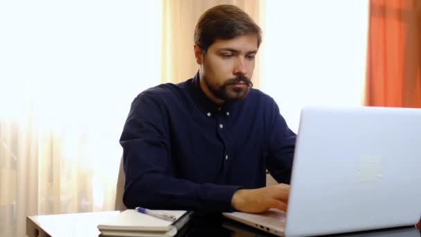 Hombre joven freelancer estudiante utilizando el ordenador portátil de trabajo desde casa en Internet - Metraje, vídeo