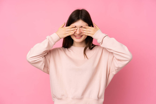 Young Ukrainian teenager girl over isolated pink background covering eyes by hands - Fotó, kép