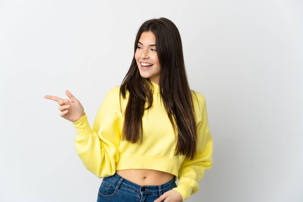 Adolescente Brésilienne isolée sur fond blanc pointant du doigt sur le côté et présentant un produit - Photo, image