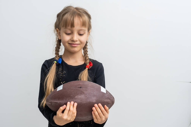 Kleines Mädchen mit einem Rugby-Ball. - Foto, Bild