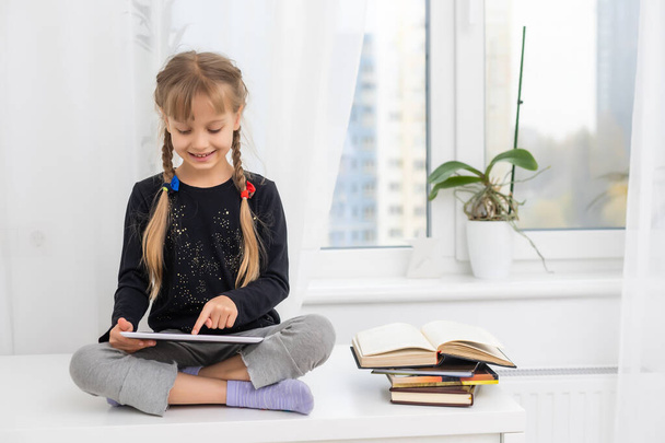 education, school, technology and internet concept - little student girl with tablet pc at home - Fotoğraf, Görsel