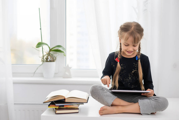 education, school, technology and internet concept - little student girl with tablet pc at home - Photo, Image