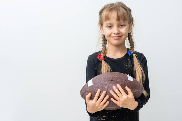Κοριτσάκι που κρατάει μπάλα του ράγκμπι. - Φωτογραφία, εικόνα