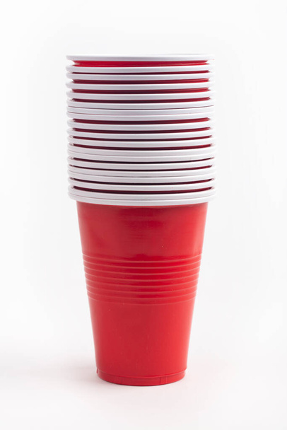 Tazas de plástico rojo apiladas aisladas sobre fondo blanco - Foto, Imagen