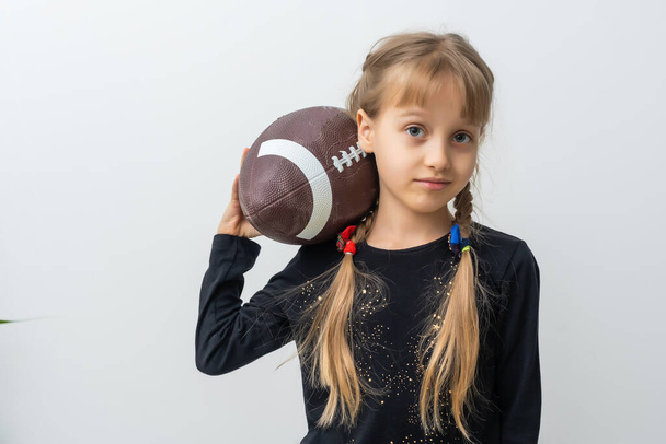 Κοριτσάκι που κρατάει μπάλα του ράγκμπι. - Φωτογραφία, εικόνα