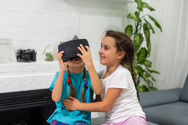 deux petites filles jouant à des jeux vidéo lunettes de réalité virtuelle - Photo, image