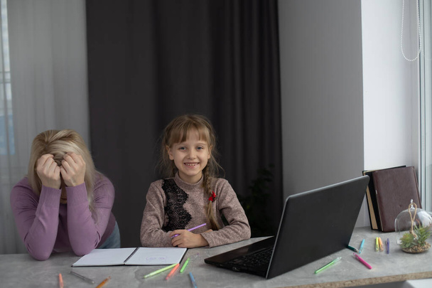 Femme avec fille faisant des devoirs sur ordinateur portable - Photo, image