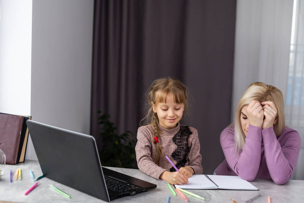 Nő segít fiatal lány laptop csinál házi feladatot az ebédlőben - Fotó, kép