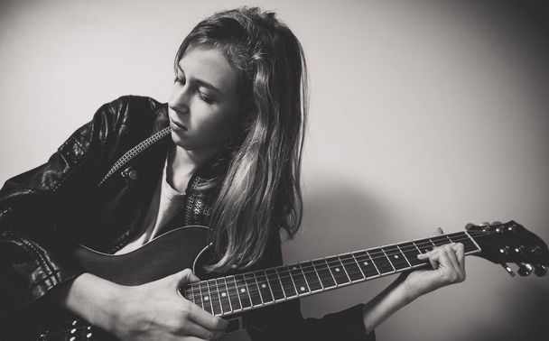 Κορίτσι που παίζει ημι-ακουστική κιθάρα στο πάρτι στο σπίτι. - Φωτογραφία, εικόνα