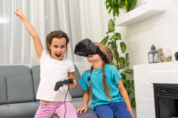 zwei kleine Mädchen spielen Videospiele Virtual Reality Brille - Foto, Bild
