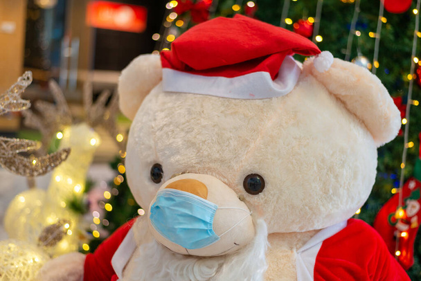 Teddy karhu joulupukki puku kulumista kasvonaamio joulun aikana pandemian COVID-19 puhkeaminen - Valokuva, kuva