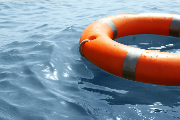 Orange life buoy floating in sea, closeup. Emergency rescue equipment - Fotó, kép
