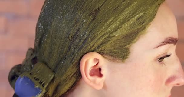 Νεαρή γυναίκα χρησιμοποιεί βαφή μαλλιών χέννα στο σπίτι, κοντινό πλάνο - Πλάνα, βίντεο