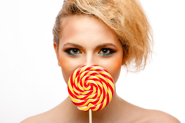 woman licks candy with beautiful make-up - Foto, afbeelding