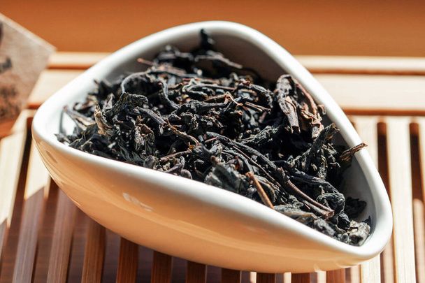 Chinesischer grüner Tee Phoenix Mountain Oolong (Fenghuang dan cong) im Tee-Präsentationsgefäß, Makrobild mit verschwommenem Hintergrund. - Foto, Bild
