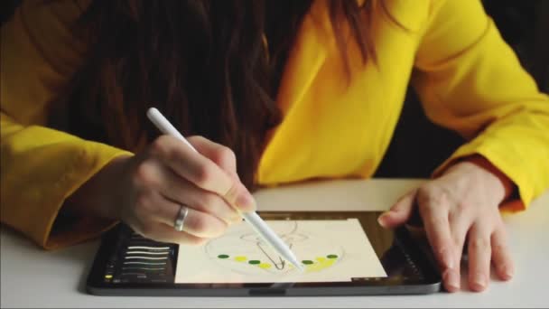 Primer plano de la mujer dibujando en touchpad con lápiz. Iluminando ropa amarilla. - Metraje, vídeo
