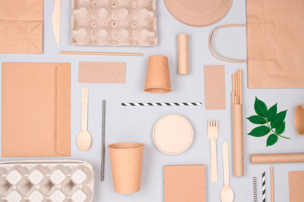 Flat lay composition with eco-friendly tableware - kraft paper food packaging on light gray background. Street food paper packaging - cups, plates, straws, containers and paper bags. Mockup image - Photo, Image