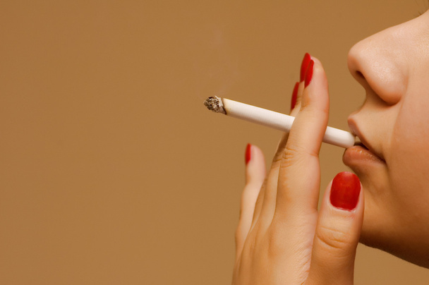 Женщина курит сигарету на оранжевом фоне
 - Фото, изображение