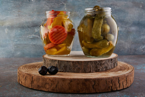 Fermented vegetarian canned food concept. Pickled cucumbers and pickled carrots in glass jars. The concept of canned food. - Photo, Image